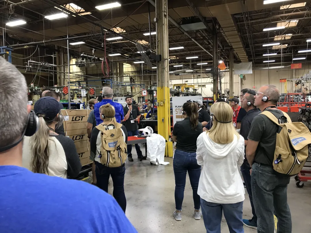 Tour group wearing headsets on a factory floor
