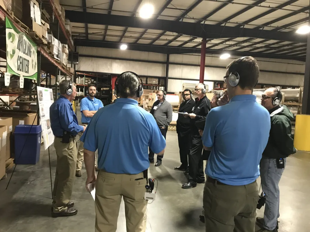Employees wearing headsets during training in a warehouse
