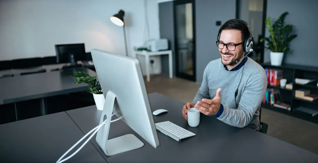 Customer service representative wearing a headset at a computer