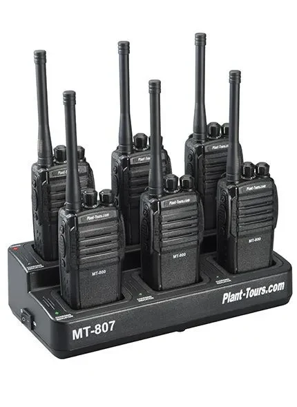 Six black two-way radios standing in a Plant-Tours.com multi-unit charging base labeled MT-807