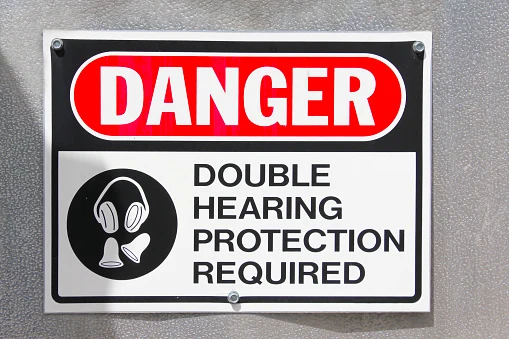 Danger sign reading Double Hearing Protection Required, with an icon of earplugs and earmuffs