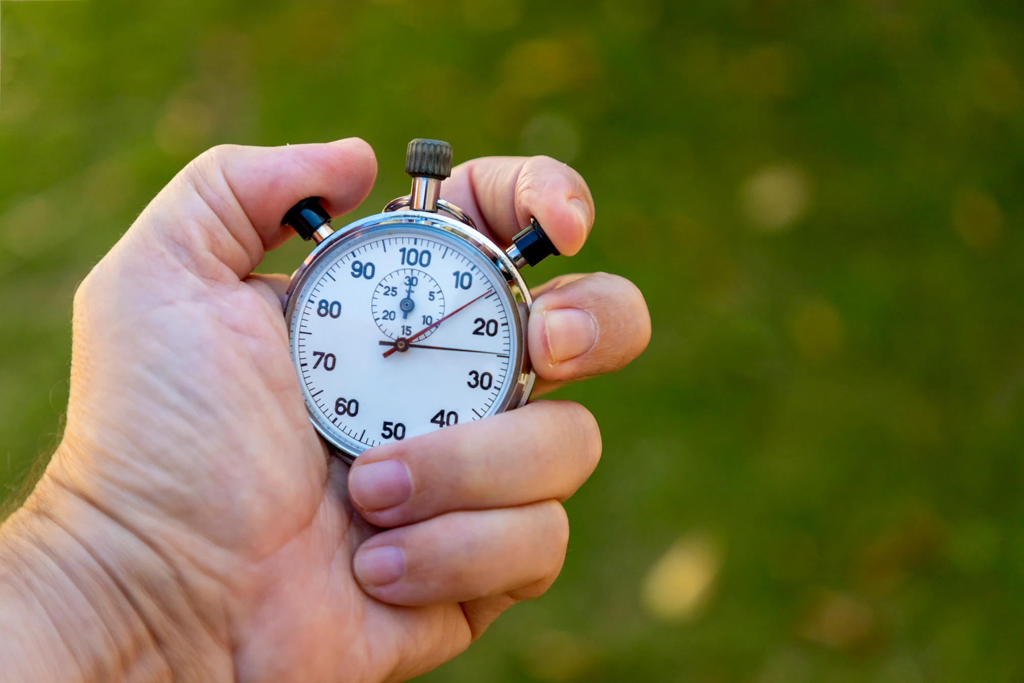 Hand holding a stopwatch outdoors